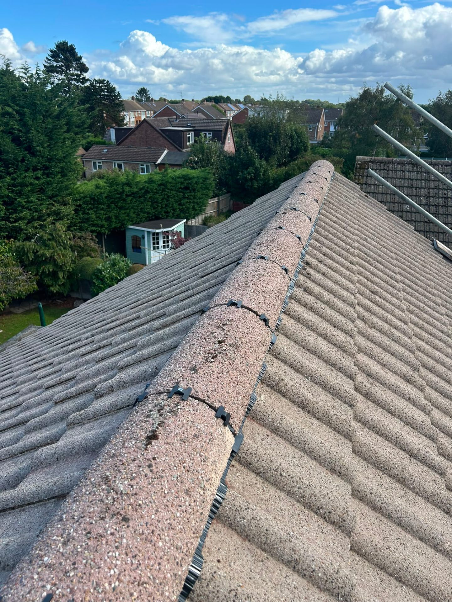 Newly installed dry-fix ridge system along a pitched tiled roof