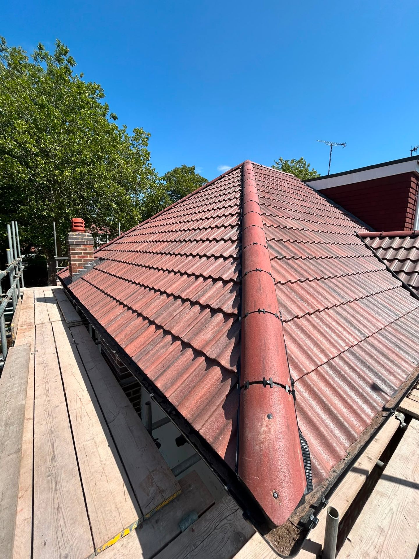 New red-brown clay tiles laid with clean ridge and hip detail by Morgan Roofing