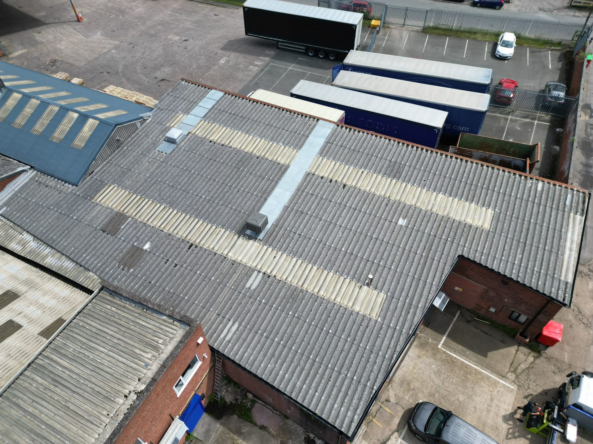 Aerial view of a large industrial roof with translucent skylight panels