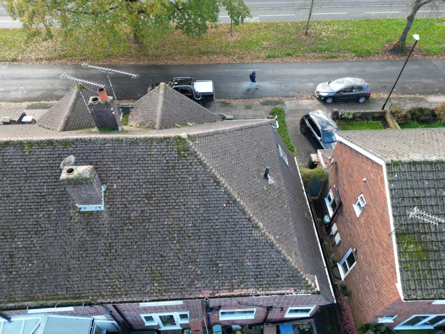 Aerial view of an older mossy brown tiled terraced roof scheduled for re-roofing