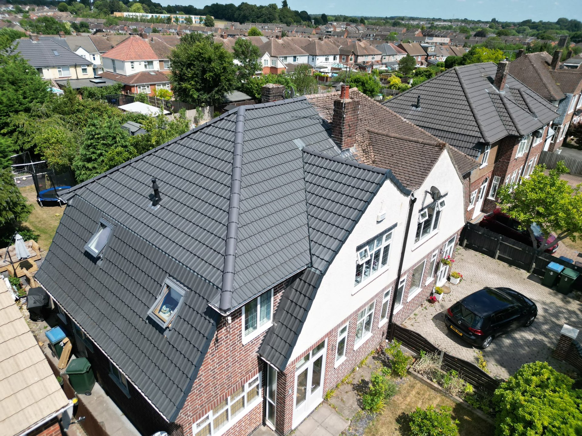 Aerial view of new dark grey tiled roof with skylights on a Coventry semi-detached home