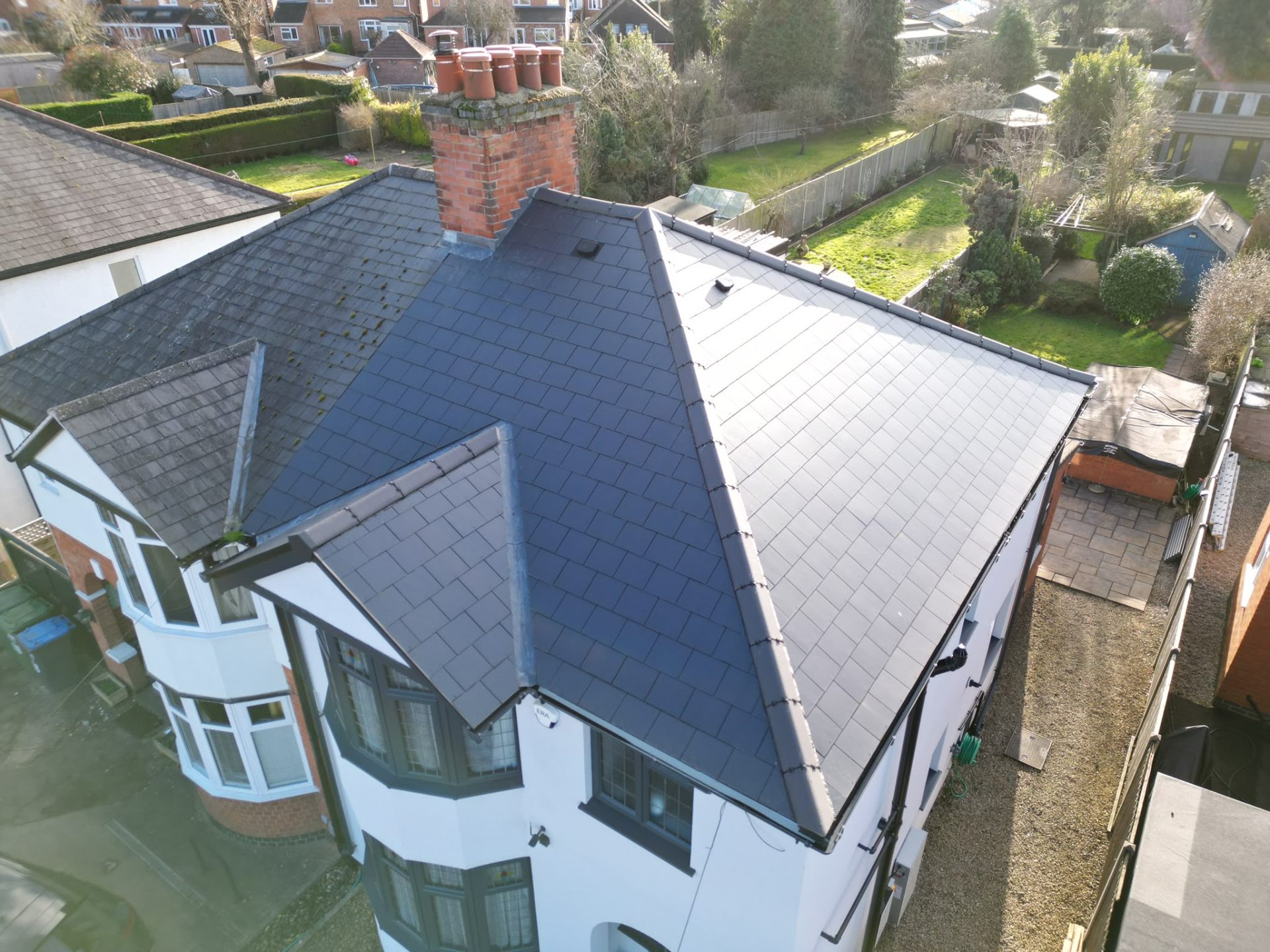 Aerial view of a newly installed slate pitched roof with chimney on a Coventry home