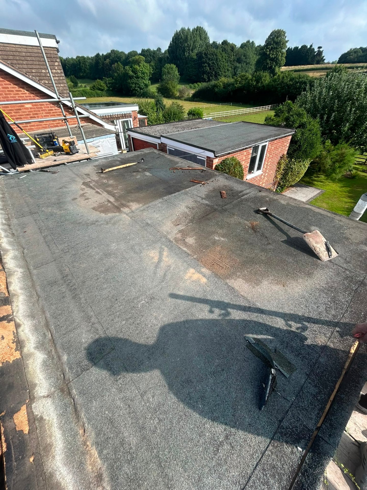 Flat roof strip-off in progress with old felt layers being removed, Coventry
